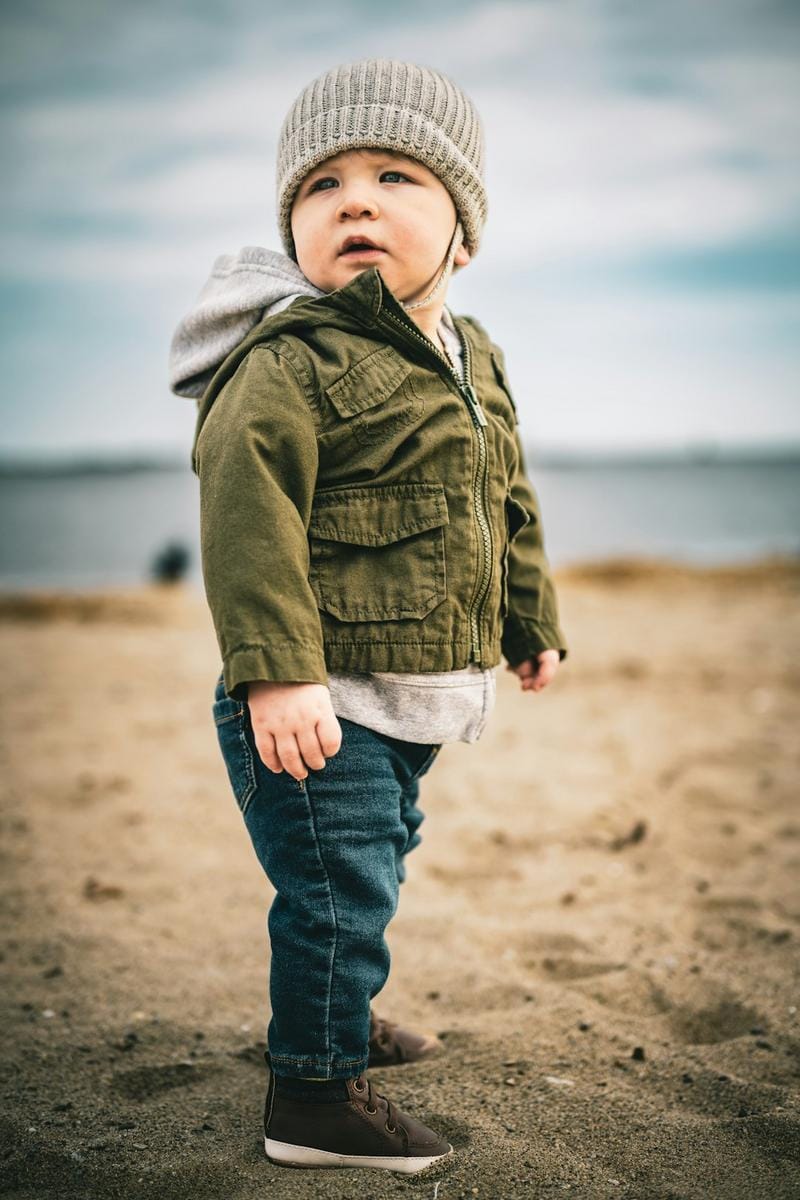 mix and match baby outfits Baby wearing a stylish layered outfit with accessories, looking cheerful in a park setting